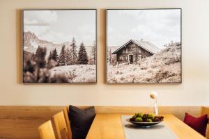 une salle à manger avec deux photos d'une cabine dans l'établissement Schneeweiss lifestyle - Apartments - Living, à Serfaus