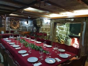 einen langen Tisch mit einem roten Tischtuch und einer Brille in der Unterkunft Casa Dos Gomes in Viseu