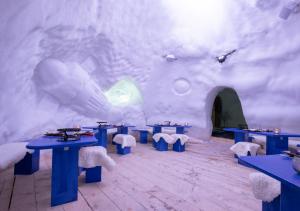 una stanza con tavoli blu e una parete innevata di Village Igloo Les Arcs ad Arc 2000