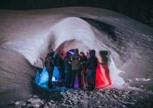 Un gruppo di persone che si trovano all'interno di una grotta di ghiaccio di Village Igloo Les Arcs ad Arc 2000