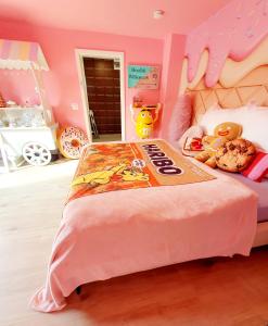 una camera rosa con un letto di benvenuto con gattini di peluche di Candypartment Sweets 'n Sleep a Gelsenkirchen