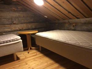 - une chambre avec un lit et un tabouret dans une cabine dans l'établissement Petäjälammen Turistimajat, à Kuusamo