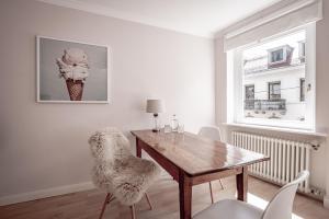 een eetkamer met een houten tafel en stoelen bij Boutique Charme Apartments in Baden-Baden