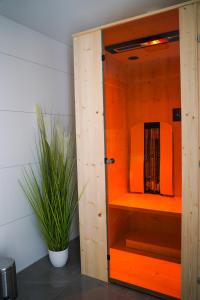 an orange cabinet with a plant in a room at Ferienwohnung Radebeul Gerlach in Radebeul