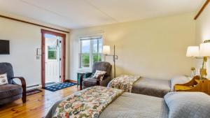 um quarto com 2 camas, uma cadeira e uma janela em Bayview Pines Country Inn B&B em Mahone Bay