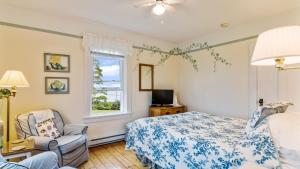 um quarto com uma cama, uma cadeira e uma janela em Bayview Pines Country Inn B&B em Mahone Bay