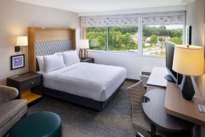 una camera d'albergo con letto e scrivania con computer di Holiday Inn Express & Suites Charlottesville, an IHG Hotel a Charlottesville