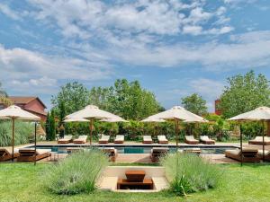 una piscina con ombrelloni e sedie a sdraio di Santa Lucia Maccarese - Residenza Agricola a Maccarese