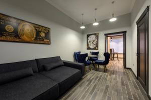 uma sala de estar com um sofá, uma mesa e cadeiras em Apart Hotel Fusion em Chernivtsi