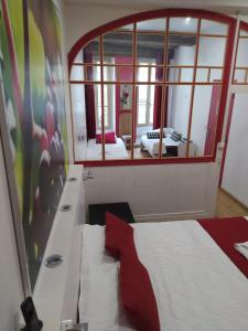 a bedroom with a bed and a large mirror at Hôtel Le Chambellan in Dijon