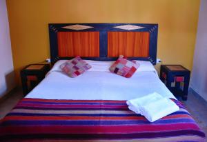 A bed or beds in a room at Hostal Paseo de los Colorados