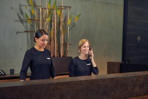 two women standing in front of a mirror talking on a cell phone at Inntel Hotels Amsterdam Landmark in Amsterdam