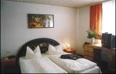 1 dormitorio con 1 cama con sábanas y almohadas blancas en Hotel Goldener Karpfen, en Aschaffenburg