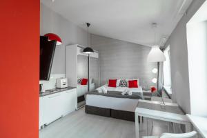 1 dormitorio con 1 cama con almohadas rojas en Stories Hub, en Leópolis