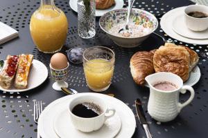 einen Tisch mit Teller und Tassen Kaffee und Gebäck in der Unterkunft Hôtel Botaniste in Paris