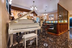 un piano en una habitación con bar en UnderSun Spa Hotel, en Grybivka