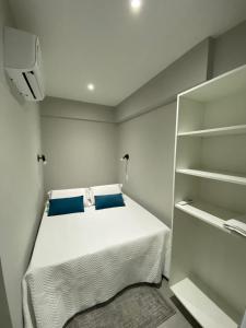 a small bedroom with a bed and a book shelf at Waikiki Apartament Ipanema in Rio de Janeiro