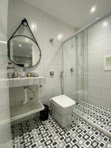 a bathroom with a toilet and a shower and a mirror at Waikiki Apartament Ipanema in Rio de Janeiro