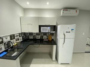 a kitchen with a white refrigerator and a sink at Waikiki Apartament Ipanema in Rio de Janeiro