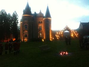 un vieux château avec un feu devant lui dans l'établissement Chateau d'Hassonville, à Aye