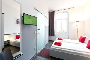 a hotel room with two beds and a tv at Hotel zwischen den Seen in Waren