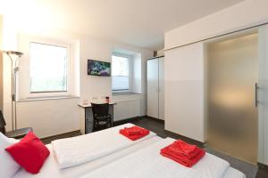 two beds in a room with red pillows on them at Hotel zwischen den Seen in Waren