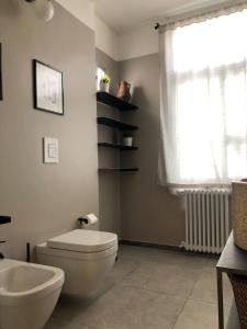 een badkamer met een toilet, een wastafel en een raam bij Caves Apartment in Bari