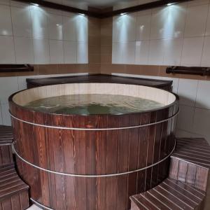 een groot houten bad gevuld met water in een kamer bij VILA URSU din SOVATA BAI -ALL INCLUSIVE- & SPA in Sovata