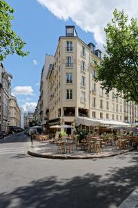 un edificio con mesas y sillas en una calle en My Maison In Paris - Louvre, en París