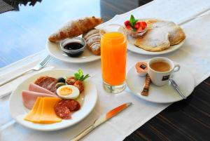 - une table avec des assiettes de petit-déjeuner et une boisson dans l'établissement Gokart Hotel, à Kecskemét