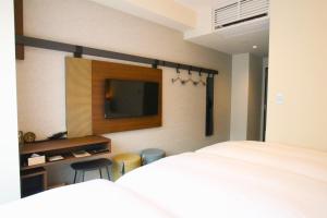 1 dormitorio con 1 cama y TV en la pared en Hotel The M's Kyoto, en Kioto