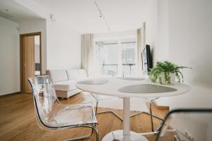 een witte woonkamer met een witte tafel en stoelen bij ÖÖ Street Premium Apartment with Terrace in Tartu