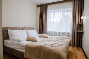 a bedroom with a large bed with white pillows and a window at ОРАНТА in Truskavets