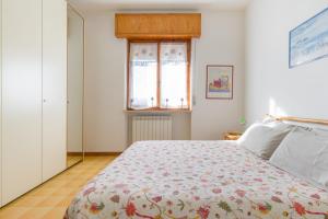 1 Schlafzimmer mit einem Bett mit Blumenbettdecke und einem Fenster in der Unterkunft Casa al vecchio mulino in Negrar