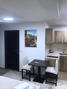 uma cozinha com mesa e cadeiras num quarto em Centar Bruno em Novi Pazar