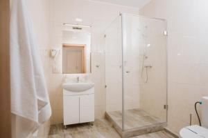 a white bathroom with a sink and a shower at ОРАНТА in Truskavets