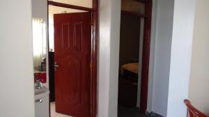 una puerta roja en una habitación con baño en AVISHAI HOMES, en Kisumu