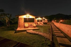 een klein huis met 's nachts verlichting bij The Gate Rinjani in Sajang