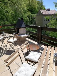 una terraza con parrilla, sillas y mesa en Pension Vila Hana, en Loket