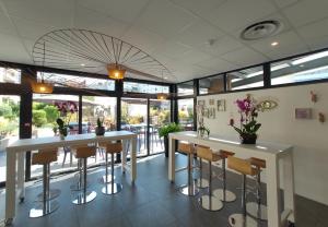 a restaurant with white tables and chairs and windows at Novotel Suites Paris Montreuil Vincennes in Paris