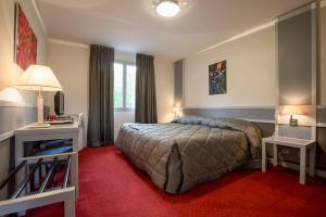 una camera con letto e tappeto rosso di Hostellerie St Vincent a Nuits-Saint-Georges