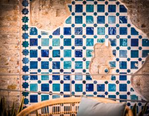 eine geflieste Wand mit blauen und weißen Fliesen darauf in der Unterkunft Hotel La Casa de Los Mosaicos in Granada