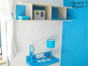 een kamer met een blauwe plank met een lamp en een spiegel bij Alojamento Tiago & Jorge Guesthouse in Nazaré