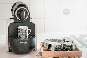 a coffee maker with cups and a tray of dishes at Ferienwohnung Seilbahn in Sankt Gilgen