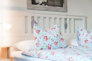 a bed with blue and pink pillows on it at Ferienwohnung Seilbahn in Sankt Gilgen