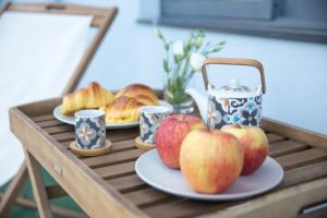 uma mesa com maçãs e pão e chávenas em Estúdio Corujeira no Porto