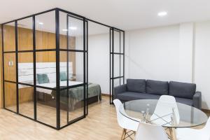 um quarto com um sofá, uma mesa e uma cama em Estúdio Corujeira no Porto