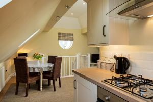 a kitchen with a table and chairs and a stove at Self contained accommodation near Delamere forest in Oakmere