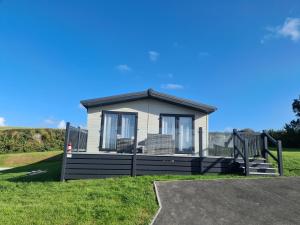 una pequeña casa en un campo de hierba en Mawgan Pads Mawgan Porth, en Mawgan Porth