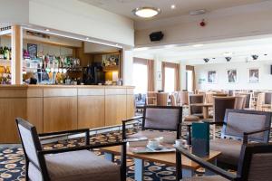 um restaurante com mesas e cadeiras e um bar em The Norbreck Hotel by Compass Hospitality em Scarborough